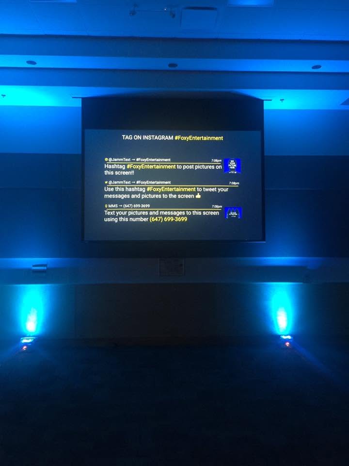 Blue uplighting with guest photo sharing screen at a Foxy Entertainment wedding